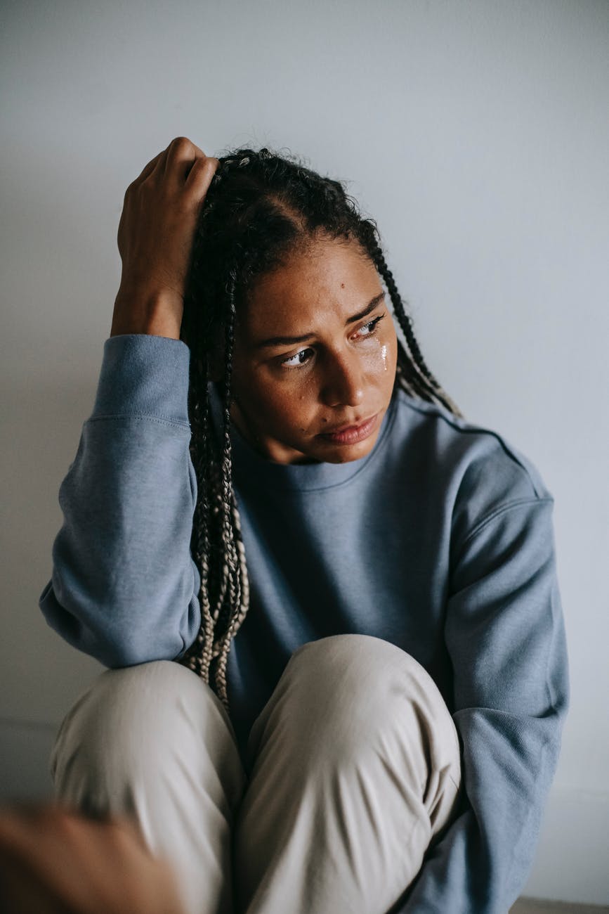 regretful black woman crying on floor